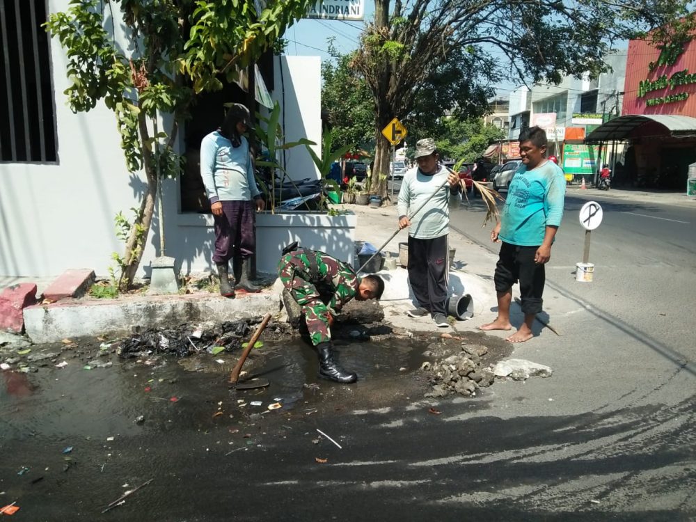 Selokan Mampet, Babinsa Kemlayan Dengan Sigap Membantu Warga Untuk Mengatasinya