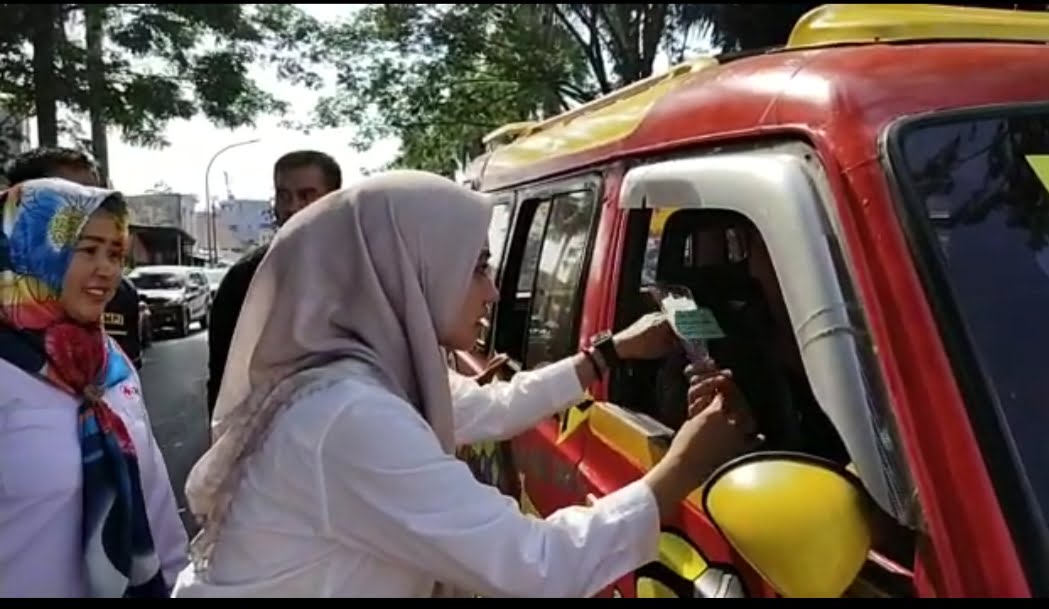 Bupati Cantik Lutra Sulsel Bagikan Bunga Kepada Para Pengendara Yang Melintas