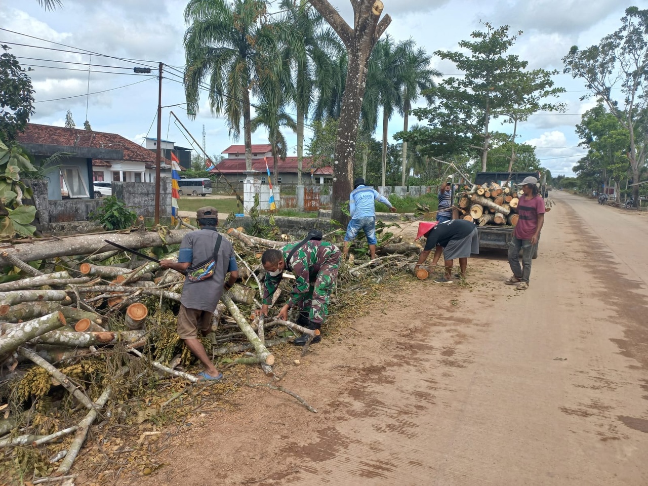 Kompak Babinsa dan Bhabinkamtibmas Sanga Sanga Gotong Royong Bersihkan Ranting Pohon