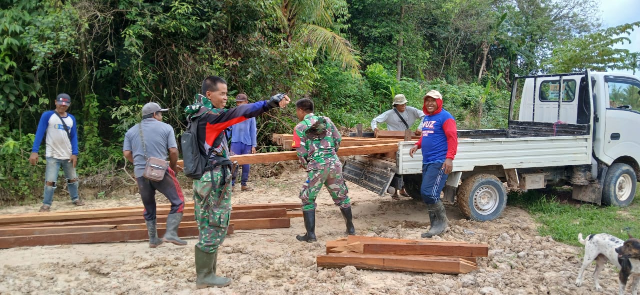 Kekompakan TNI Bersama Warga Dalam Penurunan Material Kayu Terlihat Dalam TMMD Ke 122 Di Desa Kerta Buana