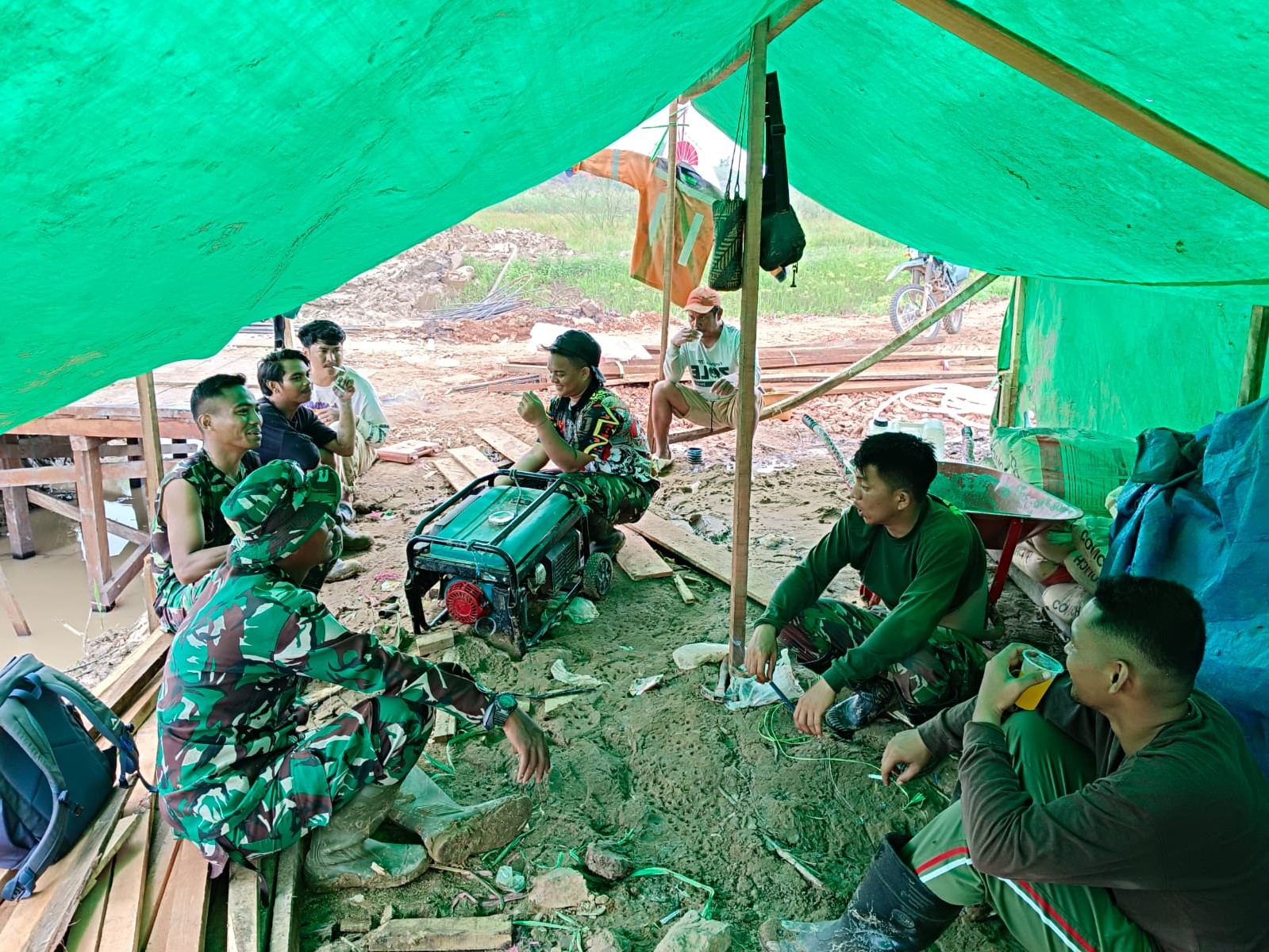 Senda Gurau Anggota Satgas TMMD dan Warga Dibawah Guyuran Hujan