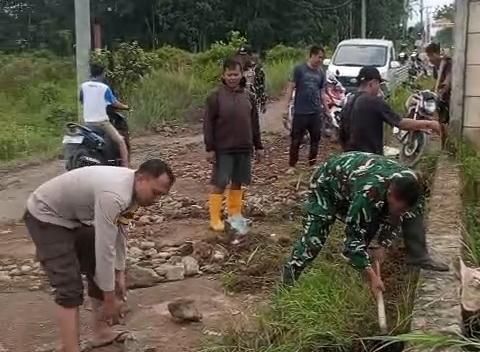 Manunggal Dengan Rakyat,Babinsa Gotong Royong Timbun Jalan Berlubang Serta Bersihakan Parit